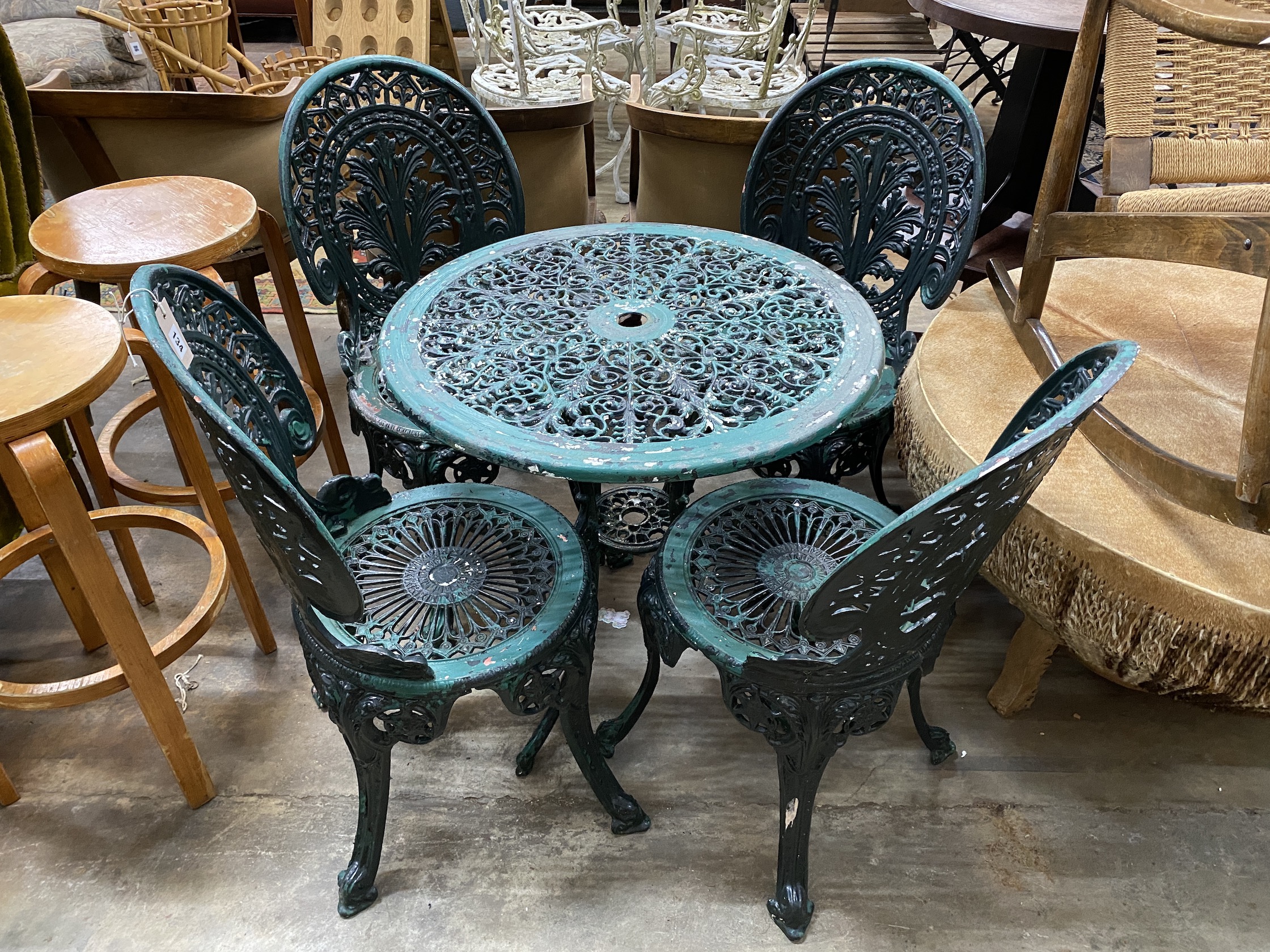 A circular painted aluminium garden table, diameter 66cm, height 65cm, together with four chairs